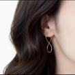 Load image into Gallery viewer, Close-up of a person wearing a gold hoop earring with a plain background
