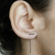 Load image into Gallery viewer, A close-up image of a woman's ear wearing a silver line earrings, showcasing the minimalist design and the placement on the ear.
